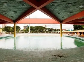 Sheltered outdoor swimming pool under a red roof